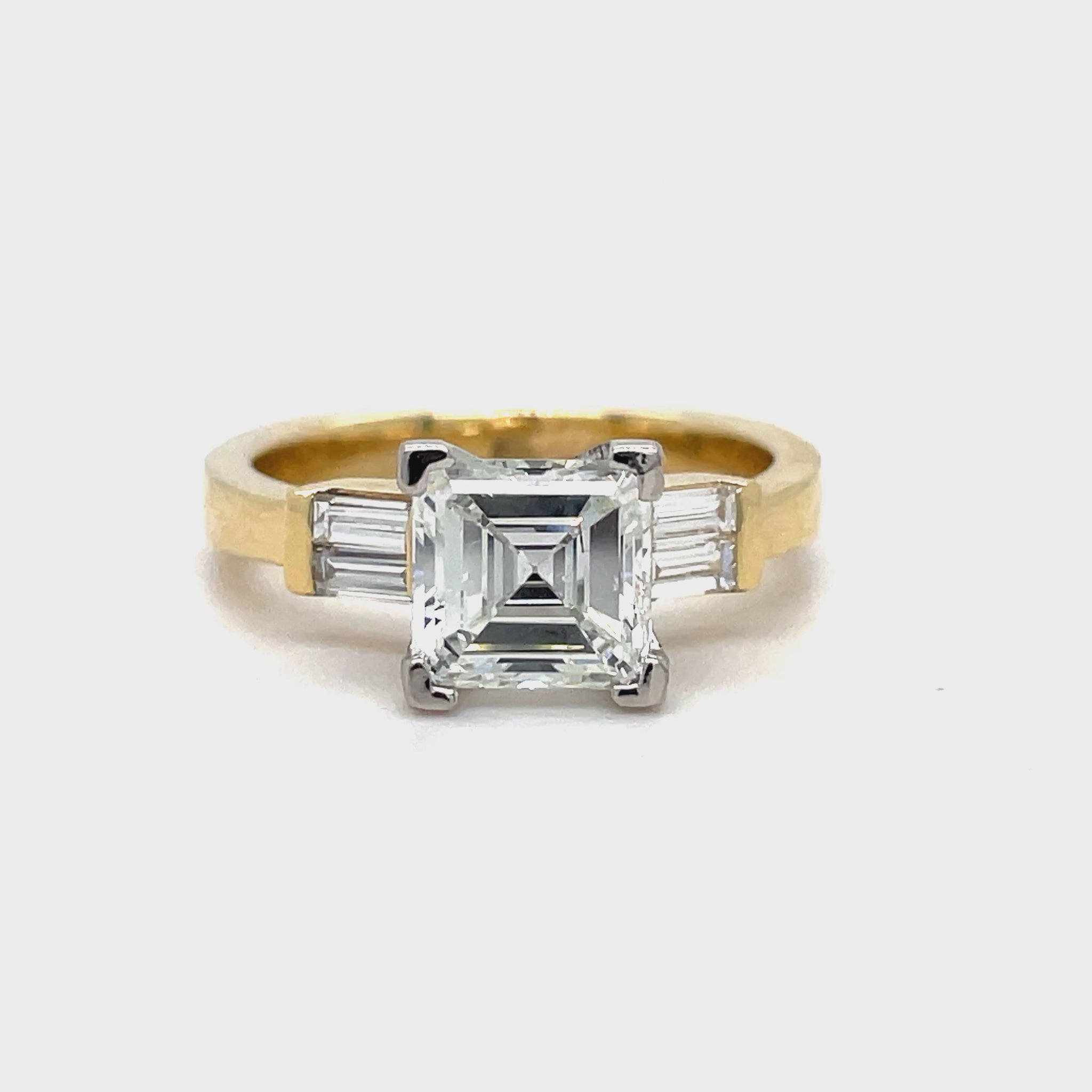 Indulge in the exquisite luxury of our Custom Made Assher Cut & Baguette Engagement Ring, featuring a 14k yellow gold band adorned with a stunning 1.71 ct assher cut diamond in a prong setting. The color G and SI1 clarity ensure brilliance, while the delicate baguette diamonds on the side add a touch of sophistication. Elevate your proposal with this exclusive, one-of-a-kind ring.