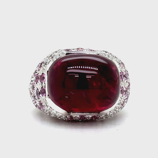 Elevate your style with this luxurious Italian-made ring. Crafted with 18k white gold, it features a stunning ruby cabochon (4.88 cts) and a vibrant pink topaz (7.60 cts). Adorned with round diamonds (0.64 cts) in a pave setting, this ring exudes elegance and sophistication.