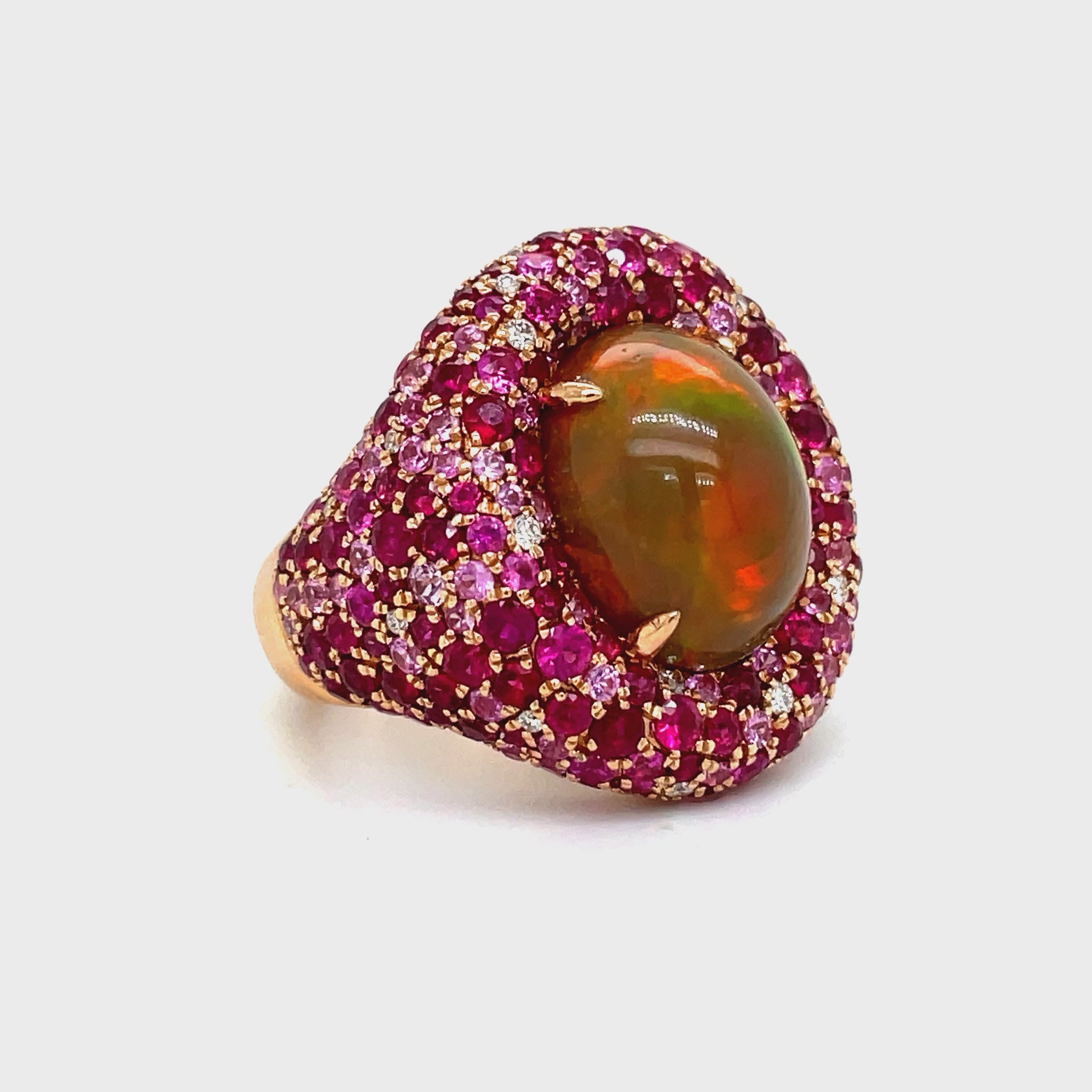 xperience the timeless elegance of our Unique Style Opal Cabochon, Faceted Rubies &amp; Diamond Dome ring. The stunning opal cabochon (5.88 cts) and faceted rubies (2.77 cts) exude sophistication, while the sparkling round diamonds add a touch of luxury. Crafted in 18k rose gold, this piece is a true work of art.