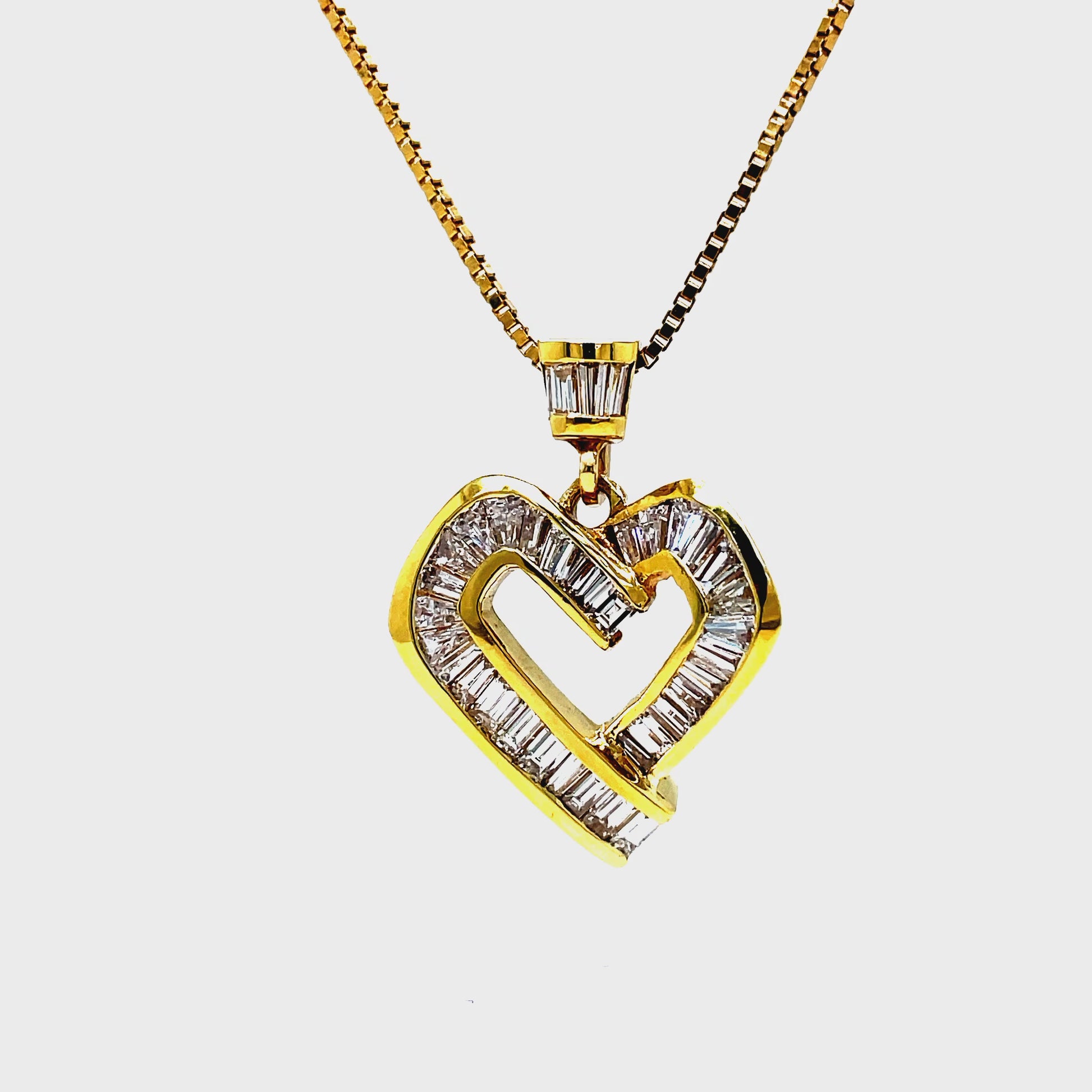 ndulge in luxury with this 18K yellow gold heart pendant necklace adorned with 2.00 carats of sparkling baguette cut diamonds. The diamonds are expertly channel set, adding to the sophistication and elegance of this piece. Complete your look with the included 18" yellow gold chain.
