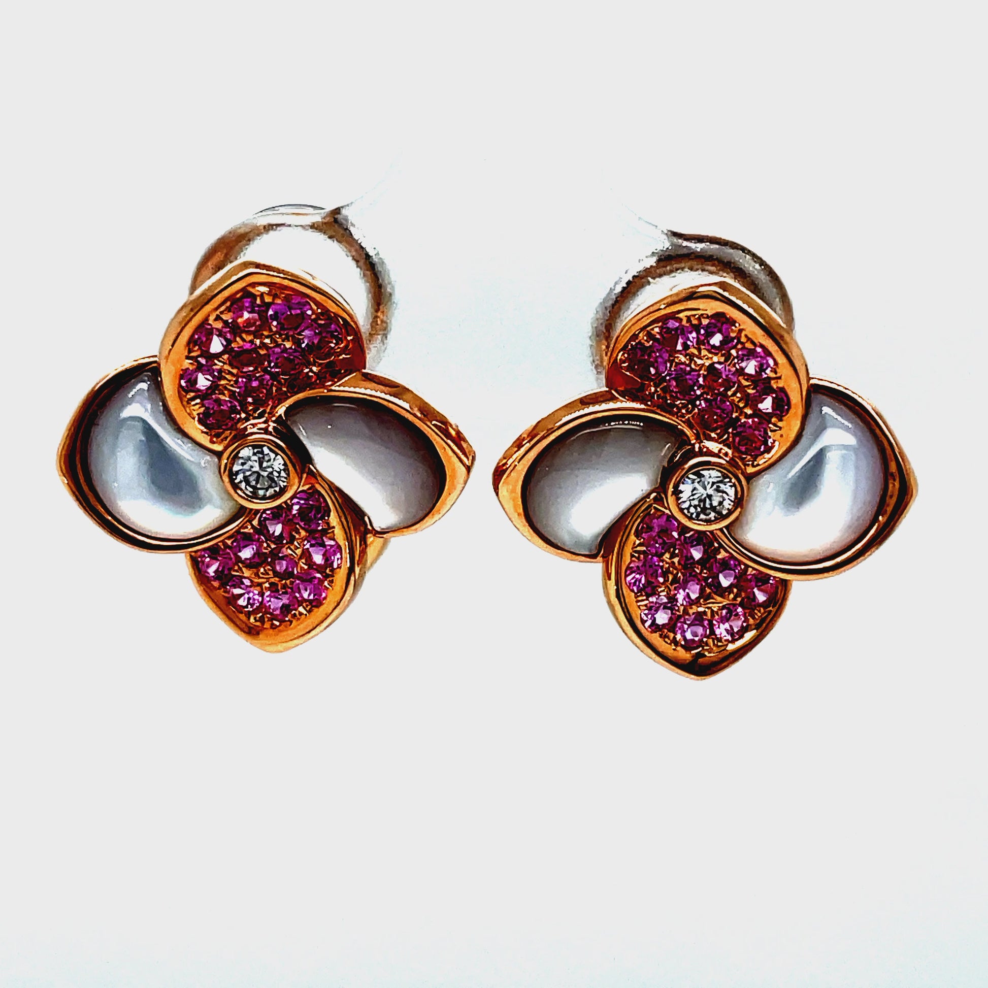Add a touch of elegance to your jewelry collection with our Pink Sapphire &amp; Diamond Four Petal Earrings. Made with 18k rose gold and adorned with 0.64 carats of pink sapphires and 0.10 carats of round diamonds, these earrings are a luxurious statement piece. The omega clip system ensures a secure fit, making them perfect for any occasion.