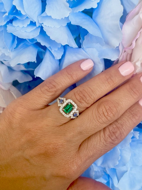 Try on view of 18k White Gold Emerald Cut emerald with Diamond Halo & Sapphire Ring